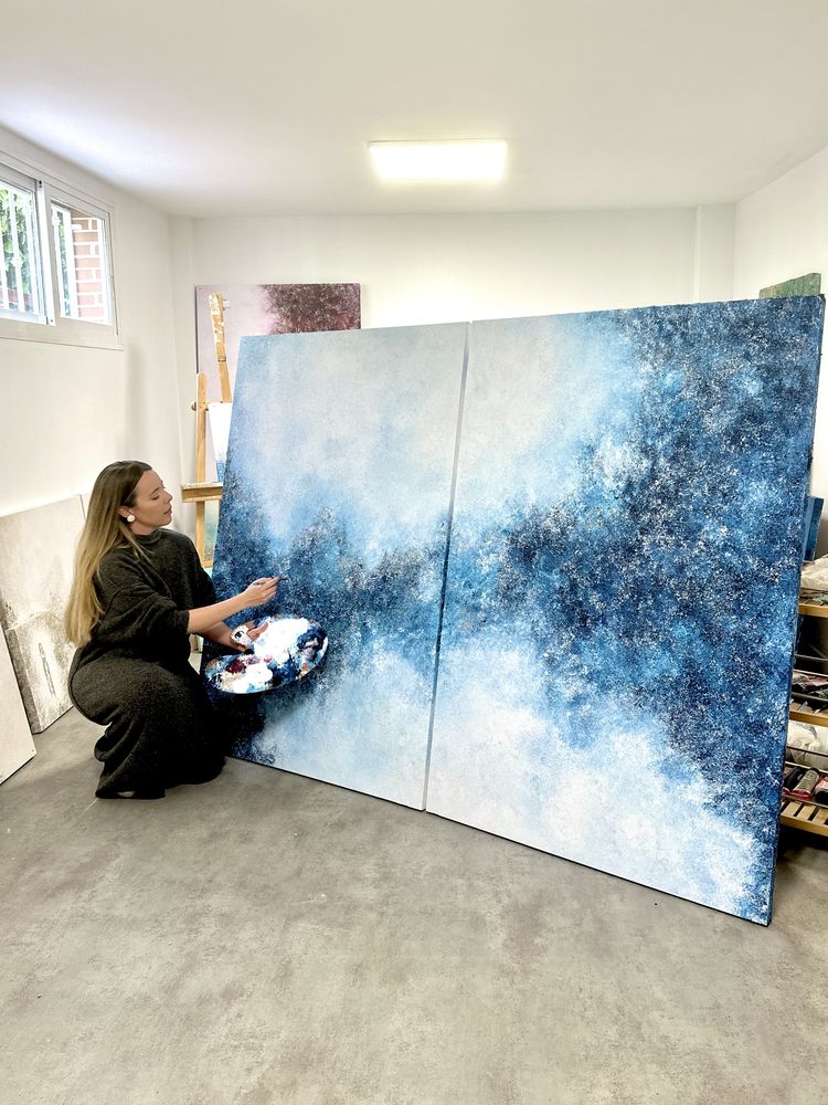 Tania pintando un díptico azul en su estudio